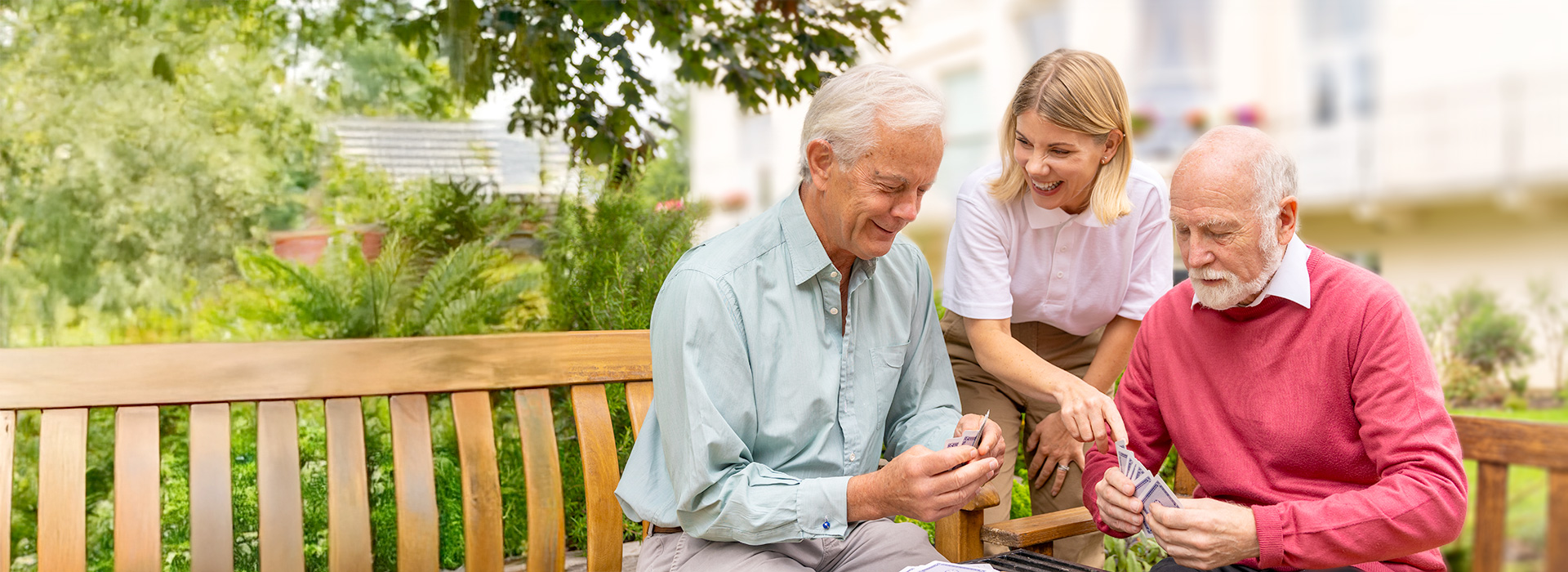 Two residents seated over a game of cards with team member